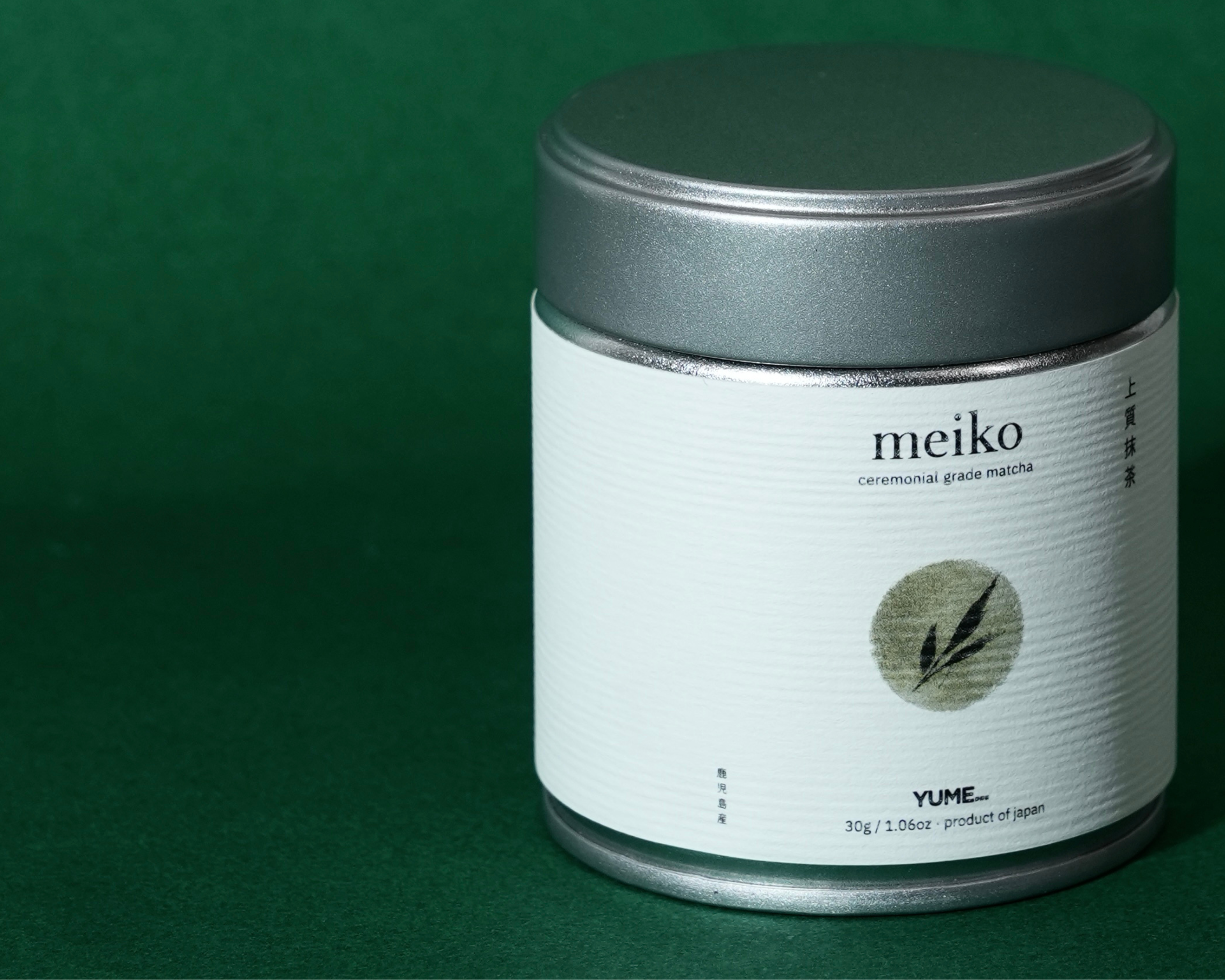 Silver Cylindrical matcha tin container with 'meiko' branding on a green background